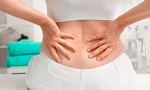 Mujer en consulta médica con dolores de espalda