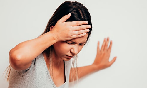 Mujer con fuertes dolores de cabeza